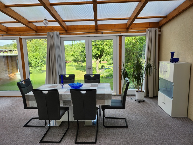Blick durch den Wintergaren in den Garten des Ferienhaus in der Schorfheide Chorin